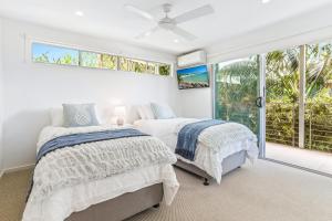 a bedroom with two beds and a window at Saltwater, Sunrise Beach in Sunrise Beach