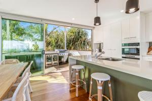 a kitchen with white cabinets and a large window at Saltwater, Sunrise Beach in Sunrise Beach