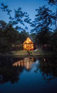 una casa con luces a un lado de un lago en Lakeside South at Live Oak Lake, en Bellmead