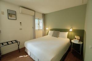 安平的住宿－安平九十八巷，卧室配有一张白色大床和两个灯
