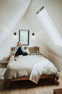 Eine Frau auf einem Bett auf dem Dachboden in der Unterkunft Lakeside South at Live Oak Lake in Bellmead