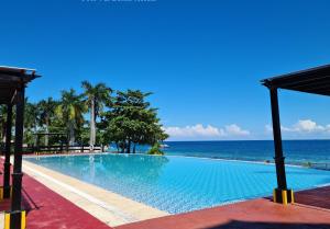 a swimming pool with the ocean in the background at La Mirada Residences in Mactan