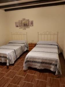- deux lits assis l'un à côté de l'autre dans une pièce dans l'établissement CASA RURAL EL OLIVO, à Logrosán