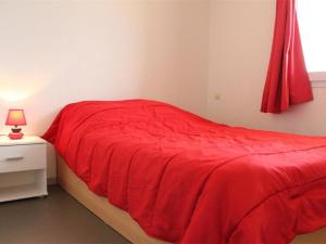a red bed in a bedroom with a red blanket at Appartement La Rochelle, 2 pièces, 4 personnes - FR-1-246-177 in La Rochelle