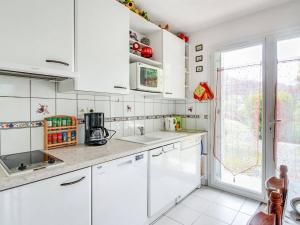 Una cocina con gabinetes blancos y una ventana grande. en T3 calme 6 pers, terrasse, jardinet, proche commodités - FR-1-402-24, en Esquièze - Sère 4 fotos más