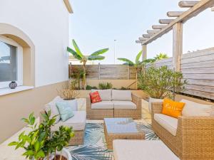 a patio with wicker chairs and couches on a balcony at Appartement Bayonne, 2 pièces, 2 personnes - FR-1-3-538 in Bayonne