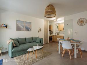 een woonkamer met een groene bank en een tafel bij Appartement Saint-Jean-de-Luz, 2 pièces, 4 personnes - FR-1-4-617 in Saint-Jean-de-Luz