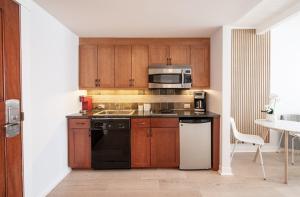 uma cozinha com armários de madeira e um aparelho preto em Winter Park FF Premium-Rated 4564 em Winter Park