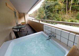 bañera con vistas a un balcón en HOTEL HanaBi 長良の湯 -大人専用-, en Gifu