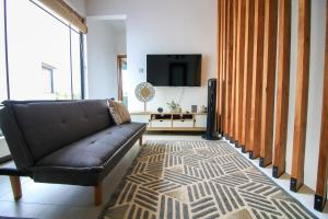 a living room with a couch and a tv at Villa Grain de café, 3 chambres piscine accès plage in Trou aux Biches