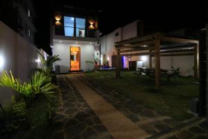 a pathway leading to a house at night at Villa Grain de café, 3 chambres piscine accès plage in Trou aux Biches
