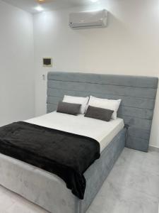 1 dormitorio con 1 cama grande y cabecero azul en Boka Bay One, en Hurghada