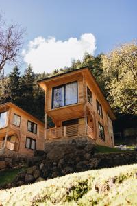 uma grande casa de madeira situada no topo de uma colina em Berona Dağ Evleri em Çamlıhemşin