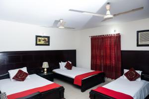 een kamer met twee bedden met rood en wit bij Ali International Hotel in Dhaka