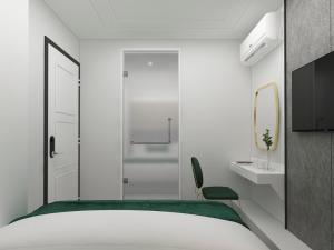 Schlafzimmer mit einem Bett, einem Waschbecken und einem Spiegel in der Unterkunft Signel Poshtel, the Rare Gem of North Borneo in Kota Kinabalu