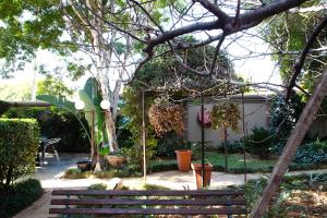 einen Garten mit einem Zaun und Pflanzen im Hof in der Unterkunft Constantia Manor Guest House in Pretoria