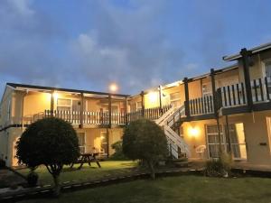 a large apartment building with a staircase in the yard at Parkside Motel and Apartments in New Plymouth