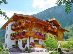 a house with flower boxes on the front of it at Fürmesli Appartements in Lech am Arlberg