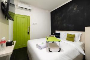 - une chambre avec une porte verte et un lit avec une table verte dans l'établissement Urbanview Hotel Bizhome Artha Gading Boulevard by RedDoorz, à Jakarta