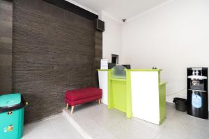 a room with a red stool and a wall at Urbanview Hotel Bizhome Artha Gading Boulevard by RedDoorz in Jakarta