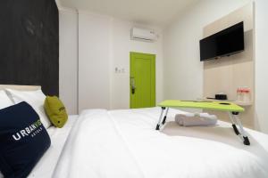 Cette chambre comprend un lit avec une table verte. dans l'établissement Urbanview Hotel Bizhome Artha Gading Boulevard by RedDoorz, à Jakarta
