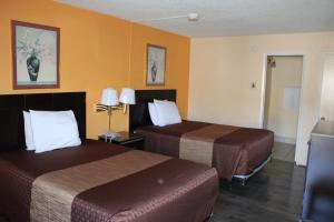 2 camas en una habitación de hotel con paredes amarillas en Budget Inn Redwood City, en Redwood City