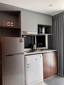 una pequeña cocina con nevera y fregadero en 12 The Residence Hotel & Apartment - SHA en Bangkok