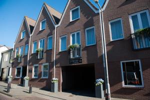 a brown brick building with a garage at Apartments Four Seasons Zuiderstraat in Egmond aan Zee