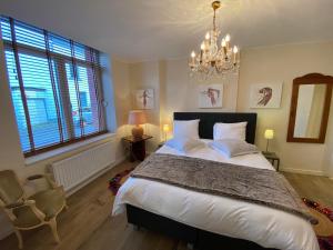 Un dormitorio con una cama grande y una lámpara de araña. en Les Ambassadeurs en Spa