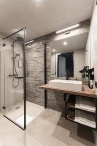 W łazience znajduje się umywalka i prysznic. w obiekcie FreshSuites & Bar w mieście Dachau