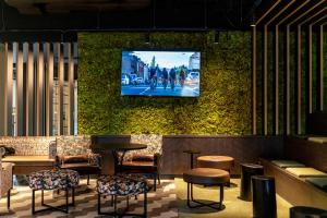 a bar with a tv on the wall at FreshSuites & Bar in Dachau