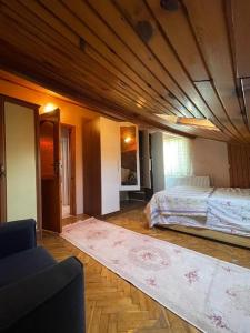 a bedroom with a bed and a couch and a rug at Senem Villa ile tatili eviniz konforunda hissedin in Silivri