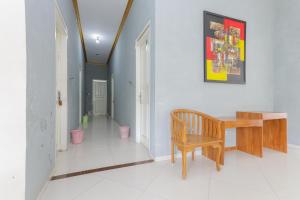 a hallway with a wooden table and a chair at RedDoorz at Villa Puncak Tidar in Malang