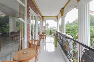 un balcón con mesa y sillas. en RedDoorz at Villa Puncak Tidar, en Malang