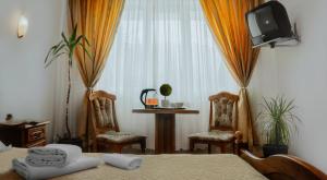 Pokój z łóżkiem, telewizorem i krzesłami w obiekcie Hotel Casa Pelerinul w mieście Durău