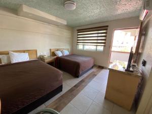 a hotel room with two beds and a television at Motel Reno in Tijuana