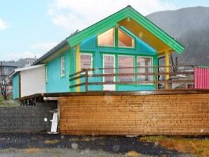 a colorful house with a fence in front of it at 6 person holiday home in M L Y in Måløy