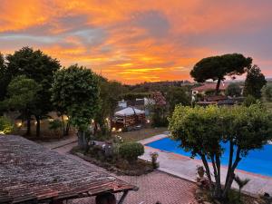 um pôr-do-sol sobre uma piscina numa villa em Il Casale di B em Acilia