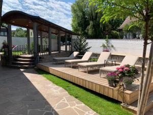 un groupe de bancs assis sur une terrasse en bois dans l'établissement Boutiquehotel Goldhahn Bio Sport & Wellness, à Aalen