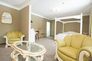 阿倫的住宿－Boutiquehotel Goldhahn Bio Sport & Wellness，一间卧室配有一张床、两把椅子和一张桌子