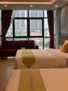 2 łóżka w pokoju hotelowym z dużym oknem w obiekcie Hotel Villa Ju w mieście Hanoi