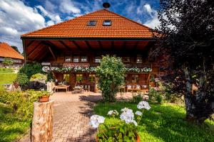 una casa con techo naranja y patio de ladrillo en Gästehaus Holzer Kreuz- Vergissmeinnicht en Fröhnd