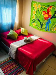 um quarto com duas camas com lençóis vermelhos e um quadro em Around Juan Santa María em Alajuela