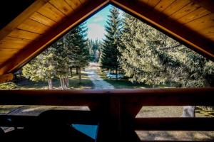 einen Blick auf den Wald aus einem Fenster in einer Hütte in der Unterkunft Ski Chalet Jahorina in Jahorina