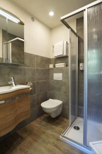a bathroom with a shower and a toilet and a sink at Hotel Pension Tyrol in Seefeld in Tirol