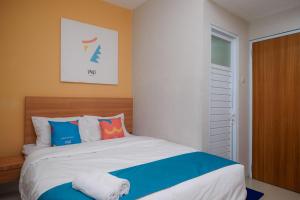 een slaapkamer met een bed met blauw en wit bij Sans Hotel Tiga Putri Semarang by RedDoorz in Semarang