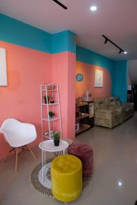a living room with colorful walls and a yellow ottoman at Sans Hotel Tiga Putri Semarang by RedDoorz in Semarang