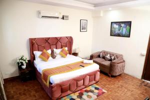 - une chambre avec un grand lit et un canapé dans l'établissement Fortune Home Service Apartment 3Bhk,E-28 Saket 1B, à New Delhi