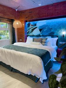 a bedroom with a large bed with a brick wall at Blue Tulip in Pusok