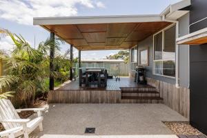 an outdoor deck with a table and chairs on a house at Island Getaway Cape Woolamai in Cape Woolamai